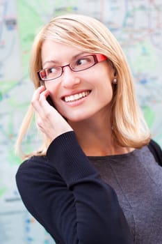 Business woman talking by cell phone infront of the metro map.