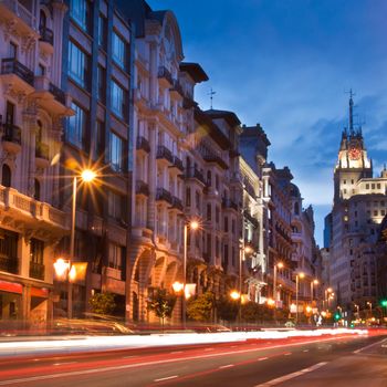 Rays of traffic lights on Gran via street, main shopping street in Madrid at night. Spain.