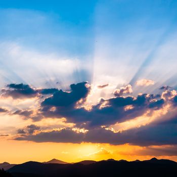 Sunset / sunrise with clouds, light rays and other atmospheric effect over the hills and mountains in Slovenia, Europe.