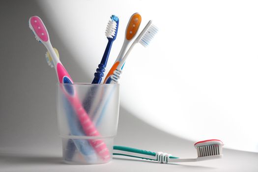 Some toothbrushes in a plastic glass