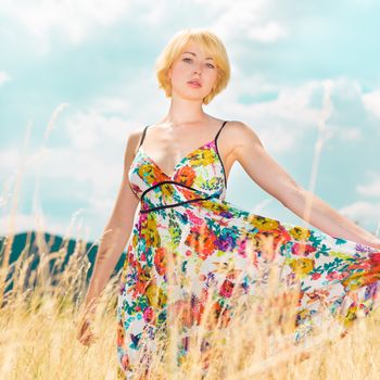 Lady enjoying the nature. Young woman enjoying the fresh air in summer meadow.