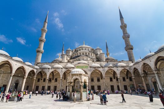 ISTANBUL - MAY 7: Tourists and prayers mixing at courtyard of Blue mosque on May 7, 2013 in Istanbul, Turkey; While still used as a mosque, the Sultan Ahmed Mosque has also become a popular tourist attraction.