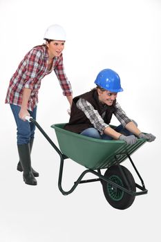 two craftswomen having fun with a wheelbarrow