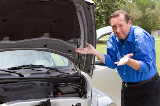 Senior man needs help and gestures in frustration about his car that is broken and needing repair work.