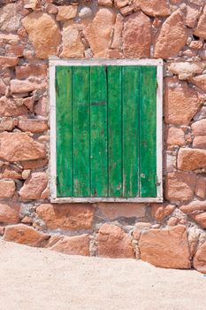 Aged grunge weathered green window shutter. Can be used as a Mediterranean background.