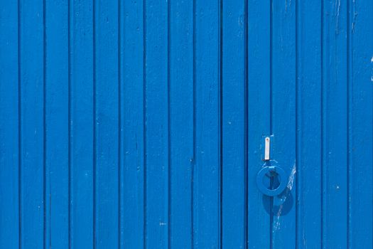 Aged grunge weathered blue door. Can be used as a Mediterranean background.