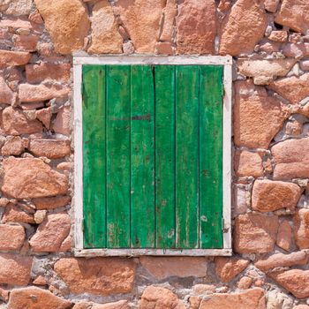 Aged grunge weathered green window shutter. Can be used as a Mediterranean background.