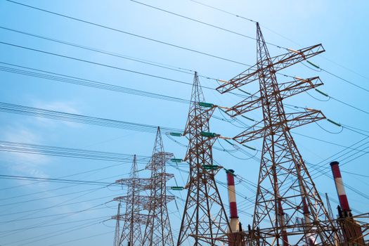 High-voltage power transmission towers in clear blue sky background.