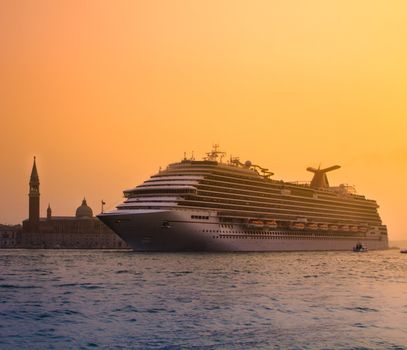 Big touristic cruiser in romantic city of Venice in sunset.