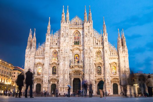 Milan Cathedral (Duomo di Milano) is the gothic cathedral church of Milan, Italy. Shot in the dusk from the square ful of people.