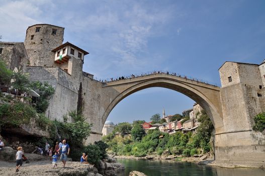 MOSTAR, BOSNIA-HERCEGOVINA AUGUST 10: Tourist at the old bridge of Mostar which was destroyed in the war and rebuild in 2004. Taken on August 10, 2013 in Mostar, Bosnia. 