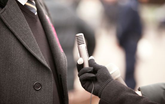 A journalist is making a interview with a microphone