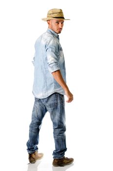 Trendy young man with jeans, denim shirt and straw hat, seen from the back