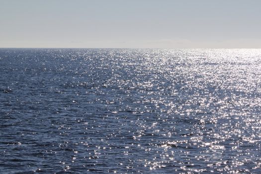 view of blue ocean water with sun reflection on it