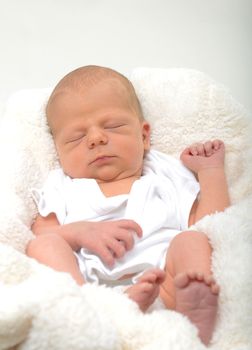 peaceful sleeping newborn baby on white blanket