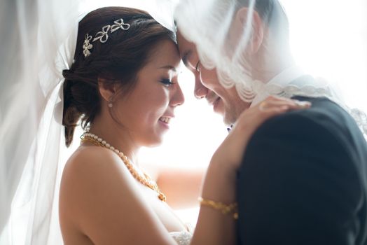 Romantic Asian Chinese wedding couple. Bride and groom dancing in love on wedding day.