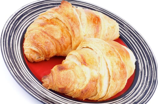 Two Freshly Baked Croissants on Red Striped Plate closeup on white background