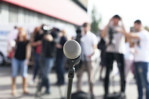 Microphone in focus against blurred audience