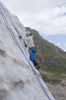 Girl climb up on the ice at glacier