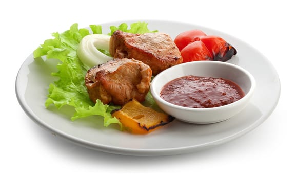 Hot roasted meat with onion, lettuce, pepper and sauce on the white plate