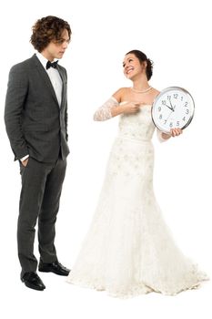 Bride holding a clock and pointing out the time