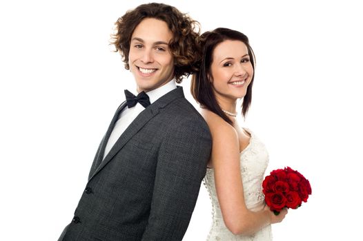 Bride and groom leaning on each other, back to back