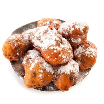a pile with oliebollen on a plate on a white background