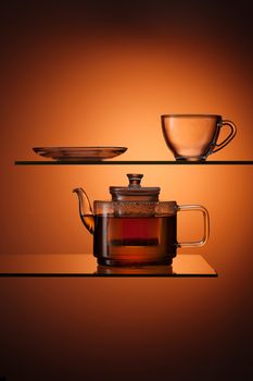 glassy tapot with tea and empty teacup