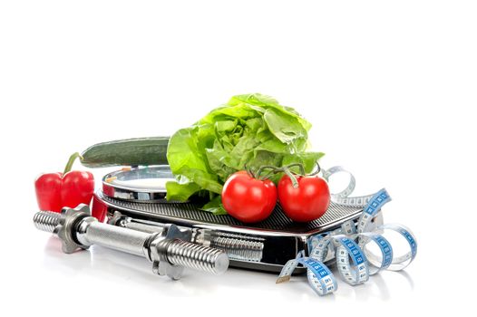 a weighing scale with vegetables, measure-tape and a dumbbell on a white background