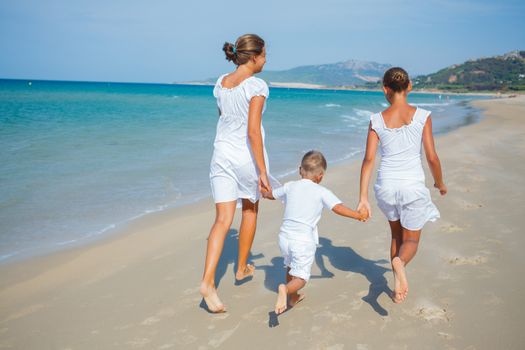 Back view of kids running on beach vacation