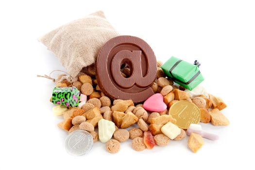 a jute bag full of pepernoten, a atpersand made of chocolate and a lot of candies on a white background