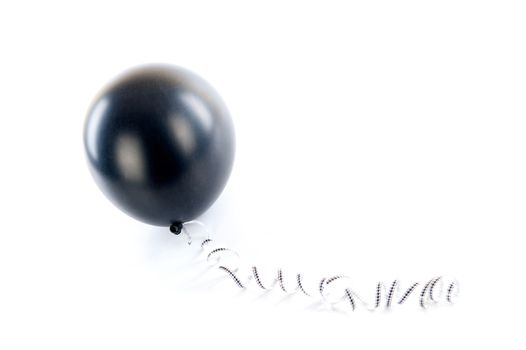 a black balloon with a ribbon on a white background