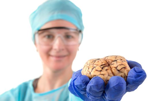 Female pathologist or medical student holding a brain in her hand extended towards the camera, isolated on white
