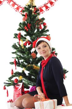 Smiling woman in Santa hat under Christmas tree over white