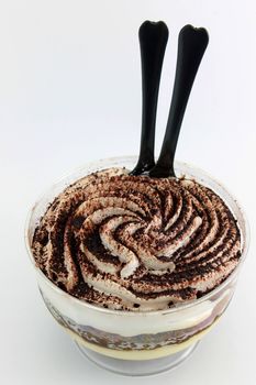Tiramisu served in a glass on white background