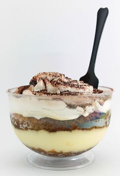 Tiramisu served in a glass on white background
