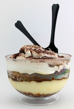 Tiramisu served in a glass on white background