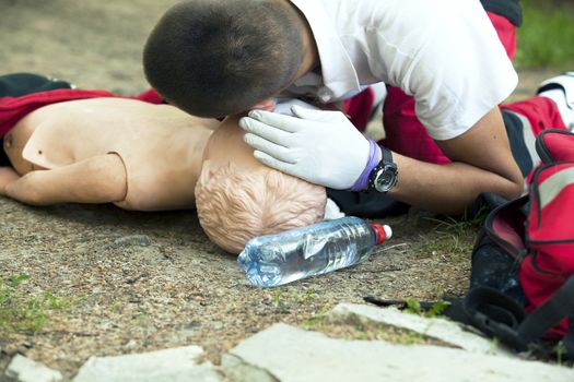 Paramedic demonstrates CPR on dummy