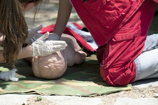 Paramedic demonstrates CPR on dummy