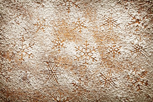 Christmas background with snowflakes. Snowflake pattern made of icing sugar on wooden table. Top view