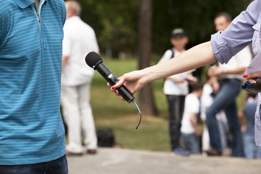 A journalist is making a interview with a microphone