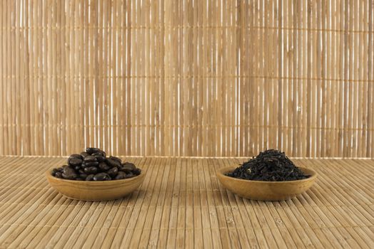 coffee beans and  tea leaves on bamboo table