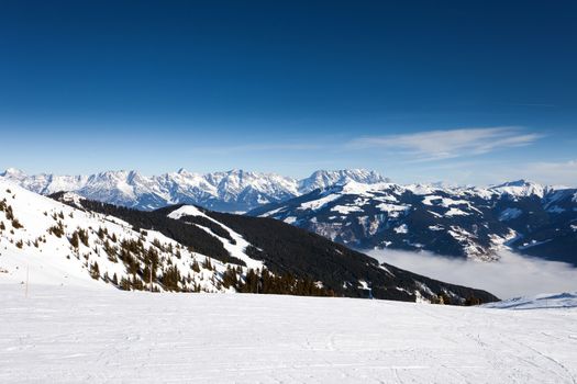 Winter with ski slopes of Kaprun resort next to Kitzsteinhorn peak in Austrian Alps