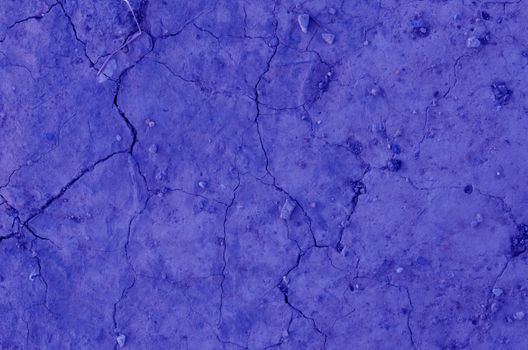 Close up dry land. Cracked ground blue color background.