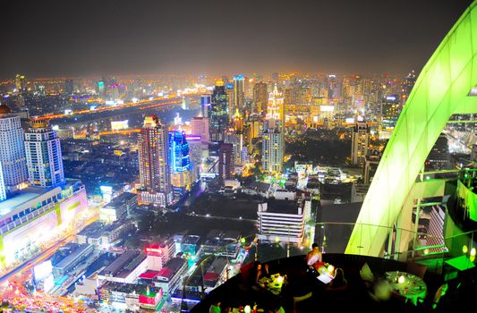 Restaurant on top of skyscraper with panoramic view of Bangkok on background, Thailand