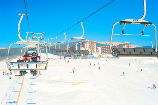 Bukovel, Ukraine - December 13, 2013: Skiers on a ski-lift  in Bukovel, Ukraine. Bukovel - is the largest ski resort in Ukraine. In 2012 it was named the most fast growing world ski resort.