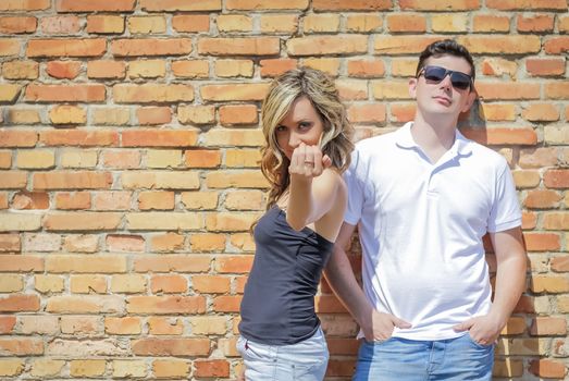 Young couple portrait in front of the brick wall background
