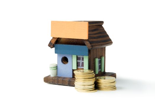 Invest in real estate concept using miniature house and gold coins