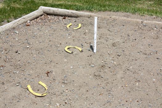 Horse shoe game in field with log sandbox