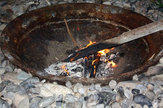 Wood burning in Fire pit surrounded by stones